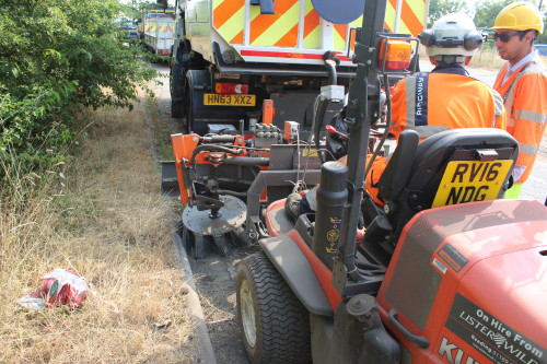 Kersten weed brush removing weeds from road edges without chemicals. Weed brush fitted to Kubota F3680.